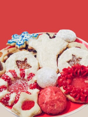 Photograph of Christmas Cookies including a Christmas Angel, Cinnamon Wreath, Hershey Kiss Surprise, Werther Original Stars, Blue and White Snowflake, almond wedding cookies, and Welch's Fruit Chew stars.