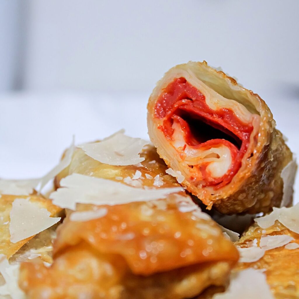 Pizza Egg Rolls - Fun Kid-Friendly Food 14 Pizza Eggrolls Recipe featuring pepperoni, cheese, sauce inside a crispy egg roll