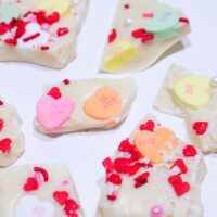 White Chocolate Sweethearts Bark made with love 3 Photo of Valentines Sweeheart White Chocolate Bark with chunks of white chocolate covered in pastel sweet hearts like Be Mine and Love, and sprinkled with a red, pink and white heart sprinkles.