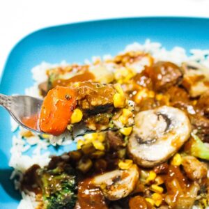 Steak Glop Easy Stovetop Dinner photo showing teal bowl on white background, square shaped, with white rice, california style vegetables, corn, mushrooms, beef and gravy. If you are looking for beef recipes and stew meat ideas...
